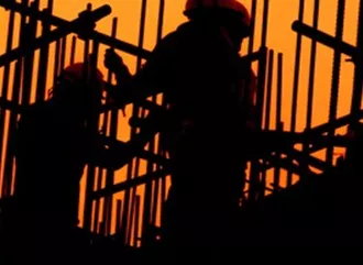 Construction workers on scaffolding finishing off the roof of a UK construction site